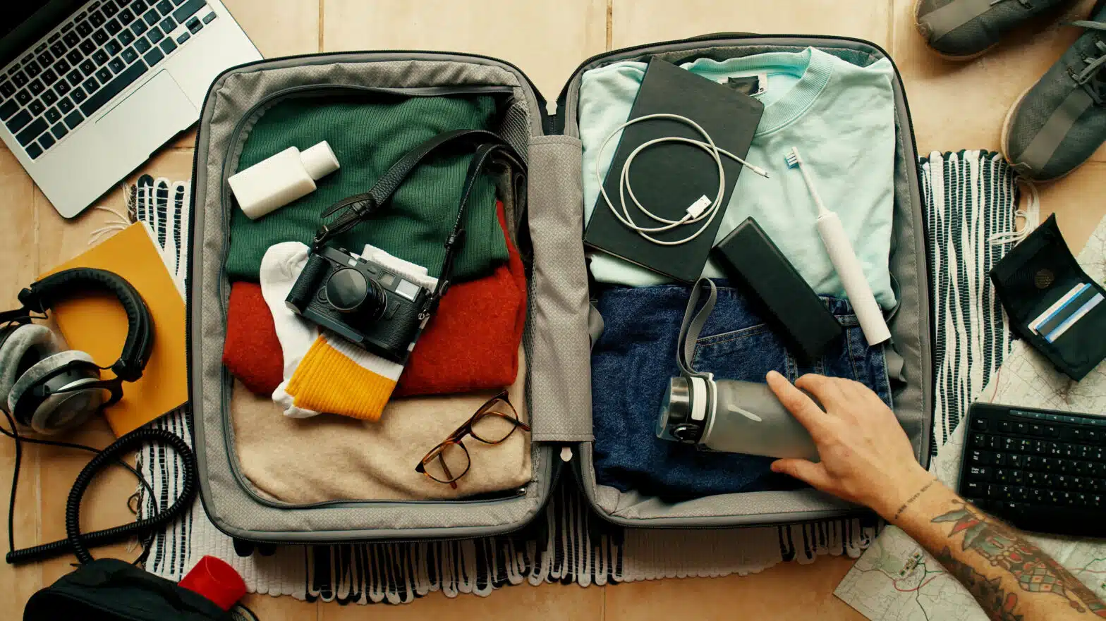 A man puts a water bottle into a suit case - How To Convince My Loved One To Travel For Rehab
