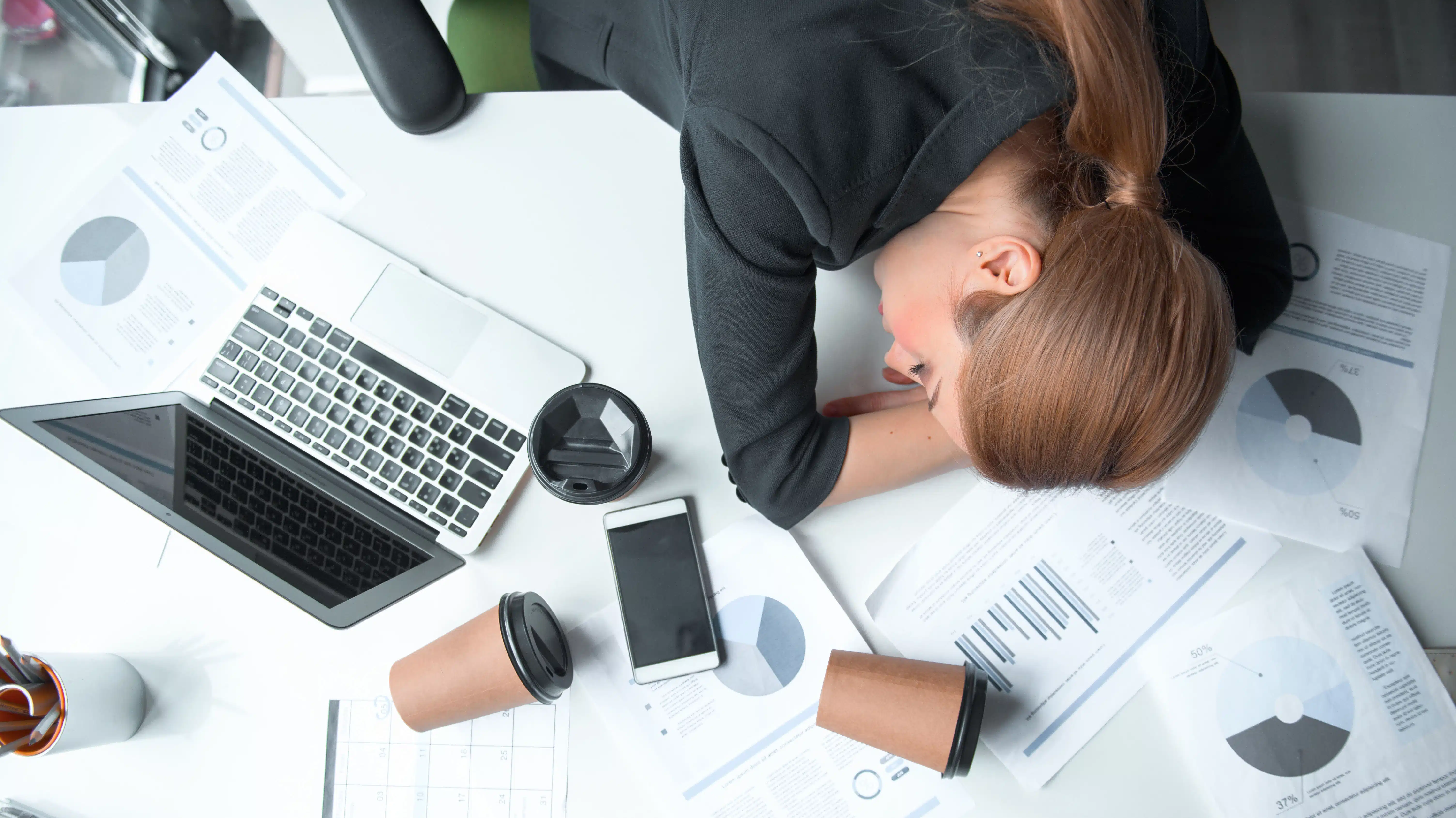 A tired woman rests her head on her work desk - Sobriety Fatigue What It Is And How To Manage It
